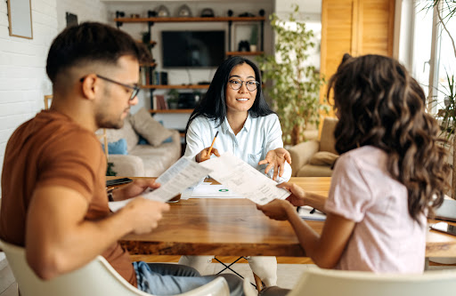 Young consultant showing new investment plans to young couple