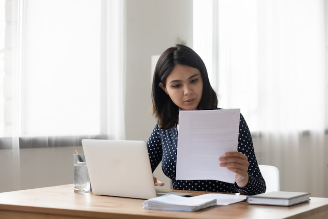 Young woman writing an offer letter before making an offer on a home