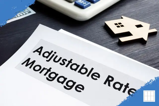 Adjustable Rate Mortgage document with calculator, cash, and wooden house model on desk.